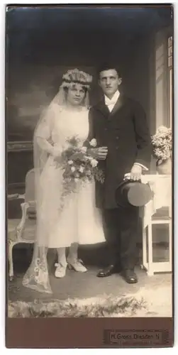 Fotografie Herm. Gross, Dresden, Leisnigerplatz 1, Portrait Eheleute im Hochzeitskleid, Schleier u. Anzug mit Zylinder