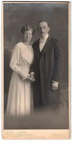 Fotografie Richard Kasbaum, Berlin, Friedrich-Str. 125, Portrait Frau un dMann im weissen Kleid und Anzug halten Händchen