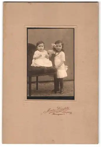 Fotografie Martin Herzfeld, Leipzig, Thornasgasse 4, Portrait zwei Kinder in weissen Kleidern an einem Sessel