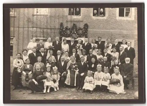 Fotografie Fotograf und Ort unbekannt, Portrait Hochzeitsgesellschaft mit Braut im schwarzen Kleid und Blumenmädchen