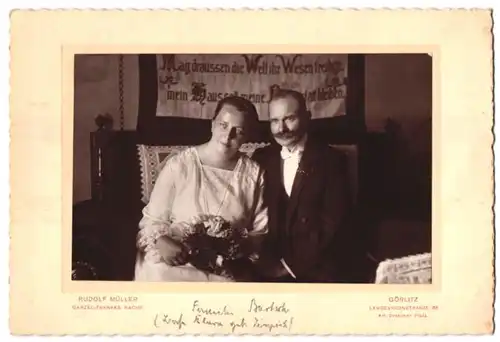 Fotografie Rudolf Müller, Görlitz, Landeskronenstr. 56, Frau im Kleid und Mann im Anzug mit Walrossbart, Sinnspruch