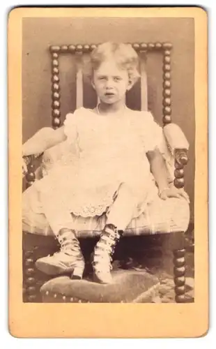Fotografie Fotograf und Ort unbekannt, Portrait Mädchen im weissen Kleid sitzend auf einem Stuhl