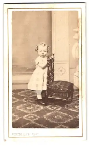 Fotografie Auberlique, Boulogne sur Mer, Rue Napoleon 21, Portrait kleines Mädchen im hellen Kleid mit Kinderstuhl