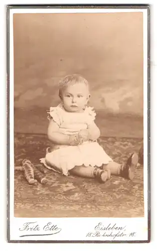 Fotografie Fritz Ette, Eisleben, Bahnhofstr. 18, Portrait Kleinkind im weissen Kleid mit Puppe an der Seite