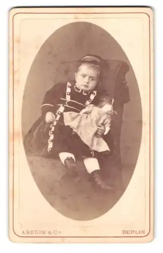 Fotografie A. Regis & Co., Berlin, Prinzenstr. 38, Portrait Mädchen im Kleid mit Puppe in der Hand