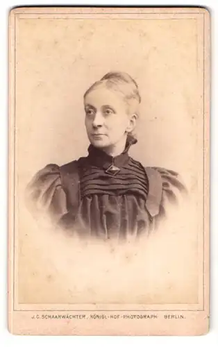 Fotografie J.C. Schaarwächter, Berlin, Portrait Dame mit Brosche trägt Kleid mit Puffärmeln