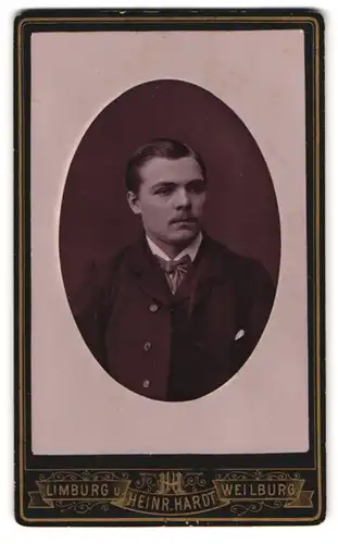 Fotografie Heinrich Hardt, Limburg, Bahnhofstrasse, Portrait junger Mann trägt Anzug & Mantel