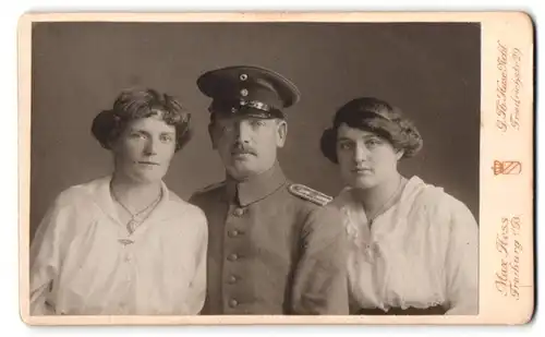 Fotografie Max Hess, Freiburg i. B., Friedrichstr. 29, Portrait Soldat in Uniform Rgt. 110 nebst zwei Frauen in Blusen