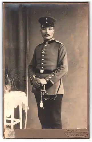 Fotografie Carl Brügmann, Wirges, Portrait Uffz. in Artillerie Uniform mit Säbel und eingestecktem Orden