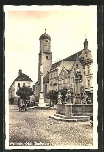 AK Weilheim /Obb., Stadtplatz mit Gasthaus, Denkmal und Brunnen