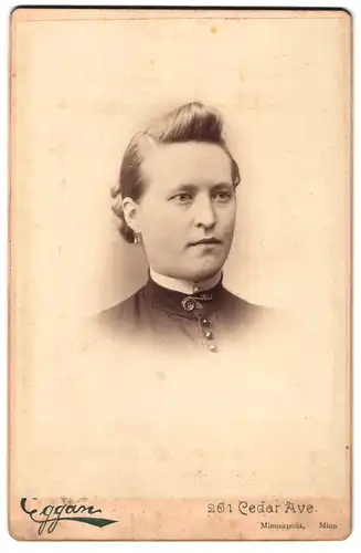 Fotografie Eggan, Minneapolis / Minn., Cedar Ave. 251, Portrait junge Frau im hoch geschlossenen Kleid mit Tolle