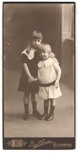 Fotografie Emil Bruno, Helsingborg, Södra Stirgatan 35, Portrait zwei kleine Mädchen im Kleid halten Hädchen