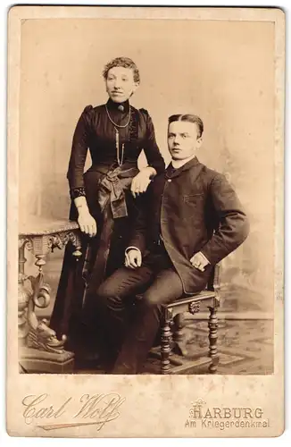 Fotografie Carl Wolf, Harburg, Am Kriegerdenkmal, Portrait junges Paar in hübscher Kleidung