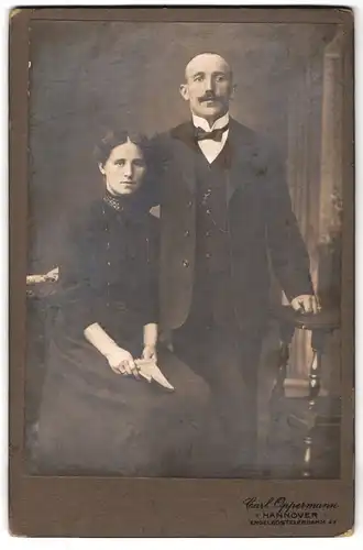 Fotografie Carl Oppermann, Hannover, Engelbostelerdamm 4a, Portrait Mann und Frau im Anzug und Kleid mit Fliege