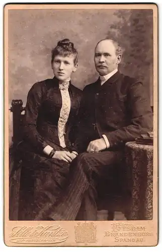 Fotografie Selle & Kuntze, Potsdam, Schwertfegerstr. 14, Portrait Eheleute im Anzug und Kleid mit Halbglatze