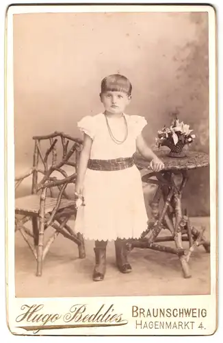 Fotografie Hugo Beddies, Braunschweig, Hagenmarkt 4, Portrait kleines Mädchen im weissen Kleid mit Topfhaarschnitt