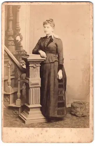 Fotografie Saccrau, Leavenworth, Kas., Shawnes St., Dame in Kleid mit Haarband lehnt an einer Säule