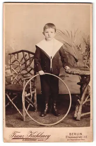 Fotografie Franz Kuhlmey, Berlin, Elsasserstr. 1-2, Kleiner Junge in Matrosenuniform mit seinem Spielreifen