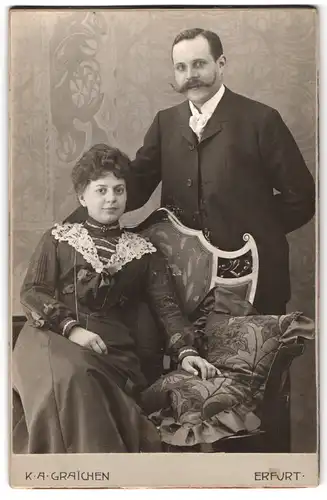 Fotografie K. A. Graichen, Erfurt, Anger 51, Sitzende Dame mit auftoupiertem Haar und stehender Herr mit Schnauzbart