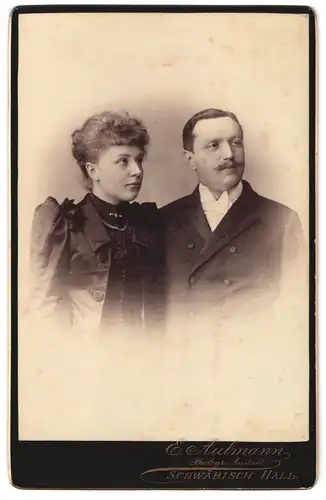 Fotografie E. Aulmann, Schwäbisch Hall, Junge Dame mit gelocktem Haar und Herr mit leichtem Oberlippenbart