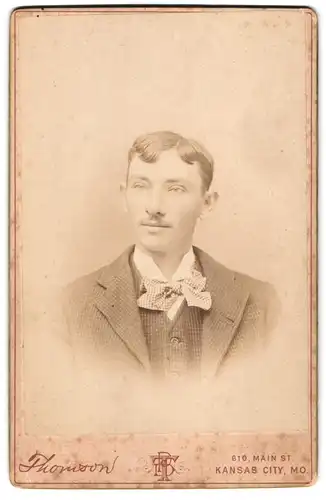 Fotografie Thomson, Kansas City, MO., Main St. 610, Junger Mann mit kariertem Anzug trägt leichten Oberlippenbart