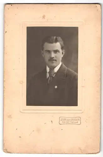 Fotografie Jean van Daalen, Gmünd, Herr mit zurückgekämmten Haaren trägt Oberlippenbart und gemusterte Krawatte