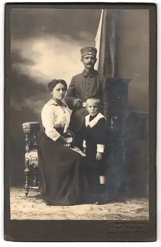 Fotografie Carl Hänsel, Lausa, Soldat in Uniform mit seiner Frau in gepunkteter Bluse und dem kleinen Sohn