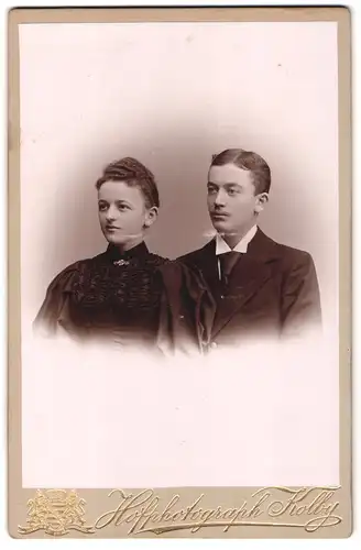 Fotografie J. F. Kolby, Zwickau i / S., Junge Dame in mit Falten geschmücktem Kleid und junger Herr mit Krawatte