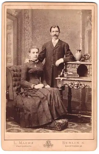 Fotografie L. Maerz, Berlin, Badstr. 62, Sitzende Dame mit Medallion und Herr mit Schnauzbart