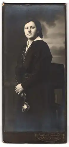 Fotografie Gerhard Müller, Rothenburg i. Hann., Brünette Dame mit Blumen im schwarzen Kleid