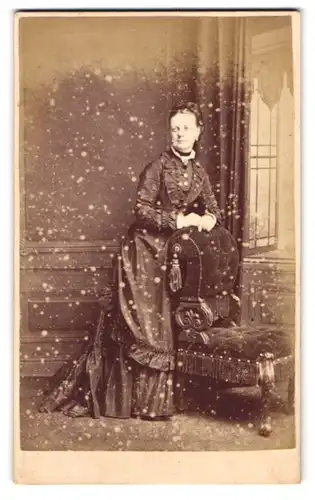 Fotografie Stuart Brothers, London, Brompton Road 47, Portrait Frau im Biedermeierkleid lehnt an einem Sessel