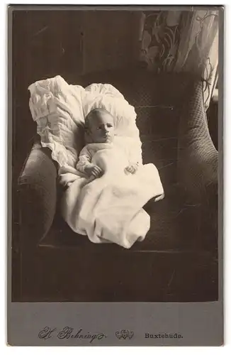 Fotografie H. Behning, Buxtehude, Knabe auf Sessel liegend