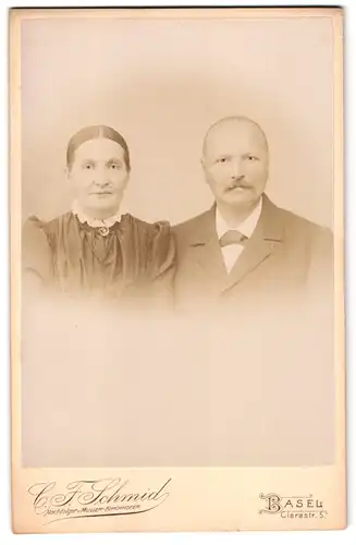 Fotografie C.F. Schmid, Basel, Clarastr. 5, älteres Paar trägt feinen Zwirn im Foto-Atelier