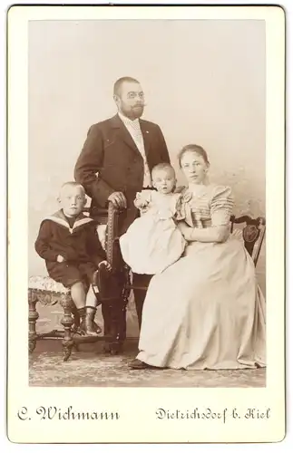 Fotografie C. Wichmann, Dietrichsdorf, Vater mit Familie im Foto-Atelier, Knabe mit Mützenband Hindenburg