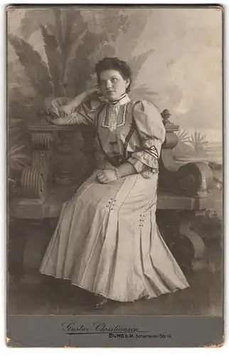 Fotografie Gustav Chrisiansen, Burg b. M., Schartauerstr. 16, junge Brünette Dame im modischen Kleid vor Kulisse