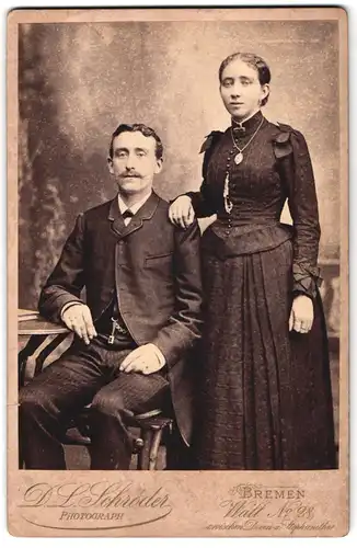 Fotografie D.L. Schröder, Bremen, Wall 28, Herr mit Schnauzbart nebst Dame mit Schmuck, Halskette mit Anhänger