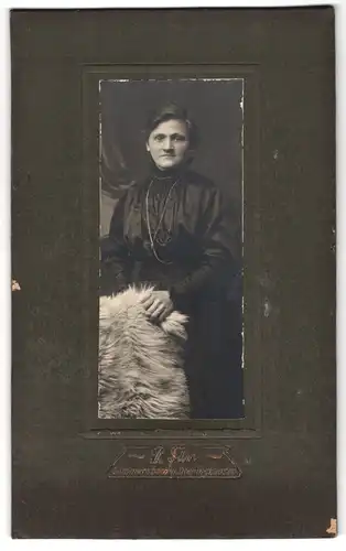 Fotografie R. Dürr, Gummersbach, Dame im schwarzen Kleid mit Felldecke