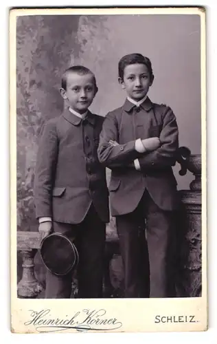 Fotografie Heinrich Körner, Schleiz, Poststr. 16, Portrait zwei junge Knaben in Anzügen mit Mütze