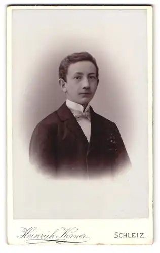 Fotografie Heinrich Körner, Schleiz, Poststr. 16, Portrait junger Knabe im Anzug mit weisser Fliege