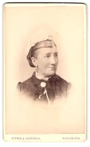 Fotografie Mann & Adcock, Norwich, Portrait ältere Dame im Kleid mit Brosche und Haube