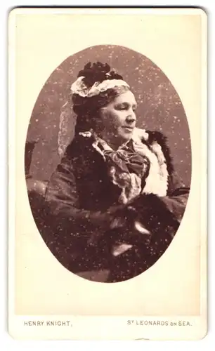 Fotografie Henry Knight, St. Leonards on Sea, Portrait ältere Dame in winterlicher Kleidung mit Haube