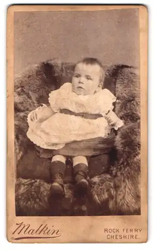Fotografie Malkin, Rock Ferry, New Chester Rd. 449, Portrait Kleinkind im Kleid sitzt in einem Pelzsessel