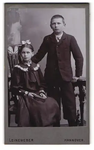 Fotografie Leineweber, Hannover, Georgstr. 30, Portrait Bruder und Schwester im Anzug und Kleid mit Haarschleife