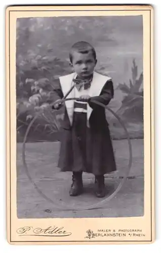 Fotografie P. Adler, Oberlahnstein, a. Rhein, Portrait kleiner Junge im Anzug mit Reifen und Stock