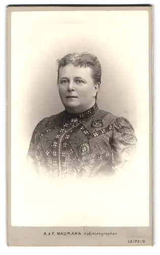 Fotografie A. & F. Naumann, Leipzig, Dorotheenstr. 6, Portrait Dame im bestickten Kleid mit Mittelscheitel