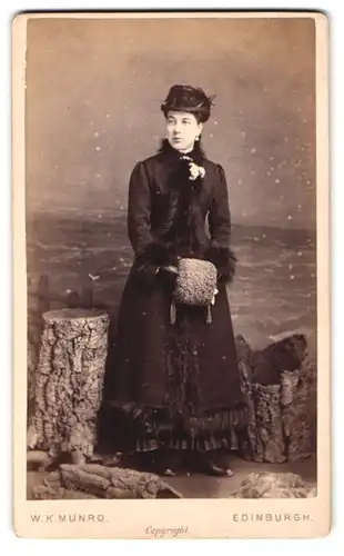 Fotografie W.K. Munro, Edinburgh, Brünette Dame mit Muff, Hut & Mantel mit Pelzbesatz