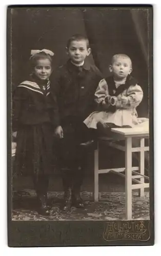 Fotografie Hellmuth, Aschersleben, Portrait drei Kinder in Kleidern und Anzug mit Haarschleife