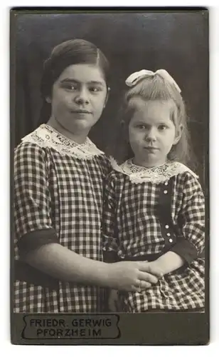 Fotografie Friedr. Gerwig, Pforzheim, Leopoldstr. 17, Portrait zwei Mädchen in karierten Kleidern mit Haarschleife