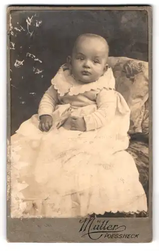 Fotografie Müller, Poessneck, Portrait Kleinkind im weissen Kleid sitzend auf einem Kissen