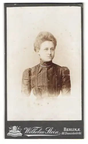 Fotografie Wilhelm Stein, Berlin, Chausseestr. 66, Junge Dame im dunklen Kleid mit Föhnfrisur